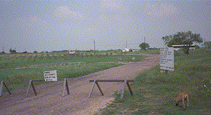[Picture of blocked-off driveway leading into site]